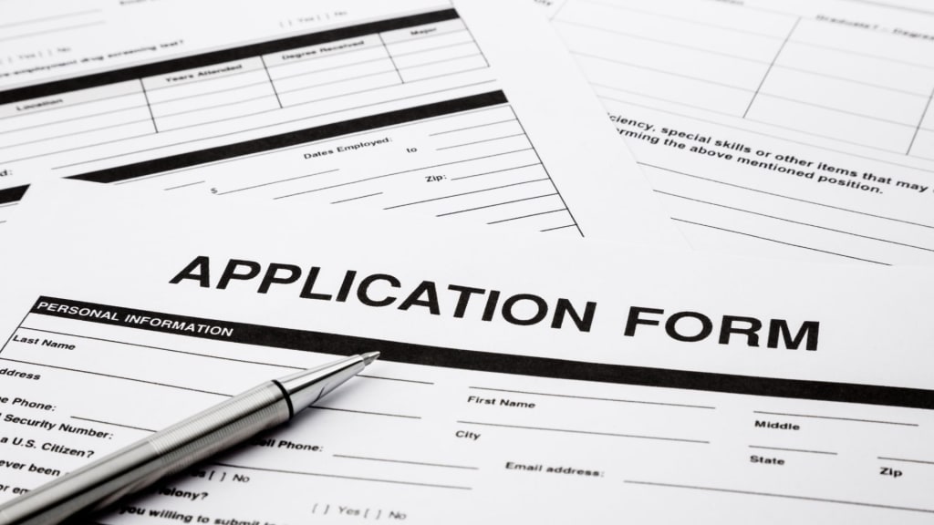 Several blank application forms on a table with a pen placed on top of them, perhaps guiding you on the path to Costa Rica citizenship by investment.